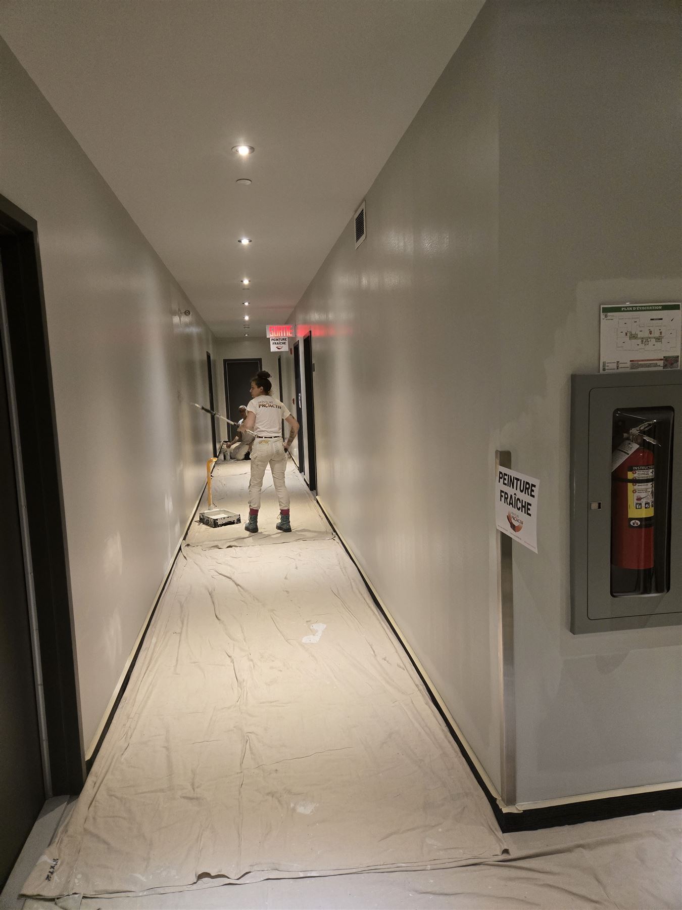 Peintre au travail dans un couloir résidentiel